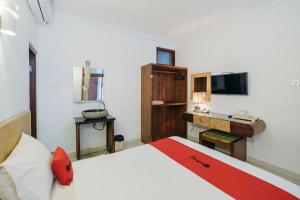 - une chambre avec un lit, un bureau et un lavabo dans l'établissement RedDoorz at Bali Kepundung Denpasar, à Denpasar