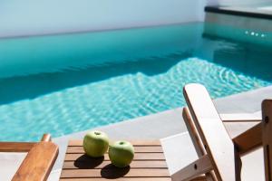 two apples sitting on a table next to a pool at SunilioS Apartments Lefkada in Lefkada Town