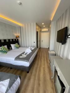 Habitación de hotel con 2 camas y TV de pantalla plana. en Old City Viva Hotel, en Estambul