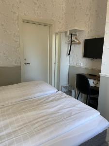 Kilafors的住宿－Norrfly Herrgård，一间卧室配有一张床、一张书桌和一台电视