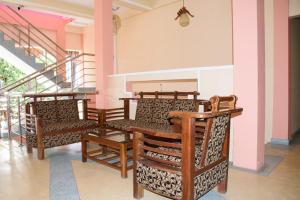 a group of chairs in a room with stairs at Gnanam Holiday Inn in Pasikuda