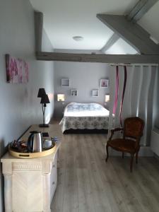 a bedroom with a bed and a table and a chair at Maison d'Hôtes Ferme d'Issonges B&B in Marigny-en-Orxois