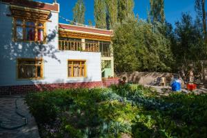 a house with a garden in front of it at Maney Homestay - Thiksey - Leh in Ranbirpura