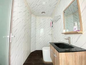 a bathroom with a sink and a mirror at Aloha Mabul Scuba Lodge in Pulau Mabul 