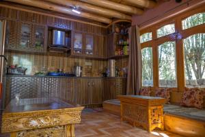 a kitchen with wooden cabinets and a table in a room at Maney Homestay - Thiksey - Leh in Ranbirpura