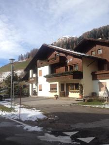 a building with snow on the ground in front of it at Ciasa Agá in Corvara in Badia