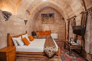 a bedroom with a bed and a tv in a room at Larissa Cave Hotel in Nevşehir