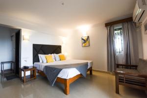 a bedroom with a large bed with yellow pillows at Raposo Resorts in Vagator