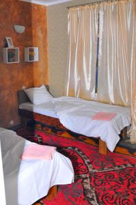 a room with two beds and a rug at Art House Sweet home in Shymkent