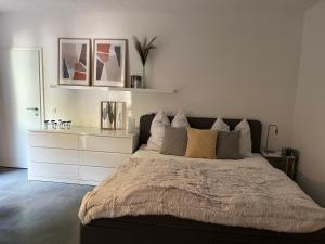 a bedroom with a large bed with two pictures on the wall at Deich Quartier 9.1 in Dorum-Neufeld