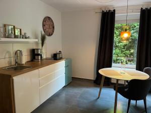 a kitchen with a sink and a table and a window at Deich Quartier 9.1 in Dorum-Neufeld