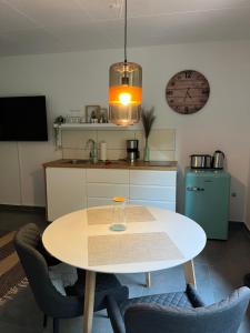 a kitchen with a table and chairs and a clock at Deich Quartier 9.1 in Dorum Neufeld