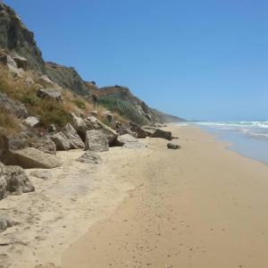 a sandy beach with rocks and the ocean at Villa Alfonso con vista mare in Siculiana Marina