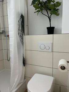 a bathroom with a toilet and a plant on the wall at Deich Quartier 9.1 in Dorum Neufeld