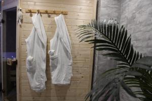 ein Bad mit weißen Handtüchern, die an einer Holzwand hängen in der Unterkunft Maison privative SPA Jacuzzi Sauna Salle de jeux in Weitbruch