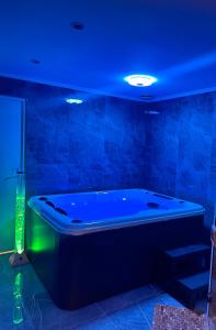 eine Badewanne in einem Zimmer mit blauer Decke in der Unterkunft Maison privative SPA Jacuzzi Sauna Salle de jeux in Weitbruch