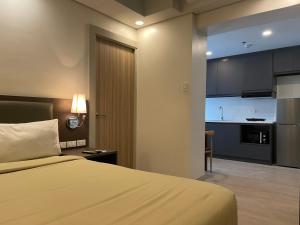 a hotel room with a bed and a kitchen at The Residences at BCCT in Manila