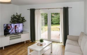 a living room with a flat screen tv and a couch at Cozy Apartment In Passow Ot Charlottenho With Kitchen in Zahren