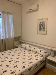 1 dormitorio con 1 cama con edredón blanco y negro en Arco Apartment - Vietri sul Mare, en Vietri