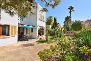 einen Garten mit einer Terrasse und einem Haus in der Unterkunft Casa Esperanza 260 by Mallorca Charme in Playa de Muro