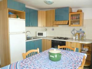 una cocina con una mesa con una maceta verde. en Attico Bellavista, en Santa Maria Navarrese