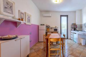 cocina con mesa y pared púrpura en Apartamento Vacanze Oleandro, en Olmedo