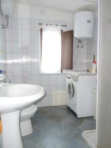 ein Badezimmer mit einem Waschbecken und einer Waschmaschine in der Unterkunft Attico Bellavista in Santa Maria Navarrese