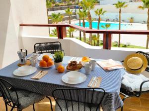 een tafel met eten erop met uitzicht op de oceaan bij Green Palms Holiday Home in Playa del Inglés