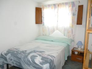 a small bedroom with a bed with a window at Attico Bellavista in Santa Maria Navarrese