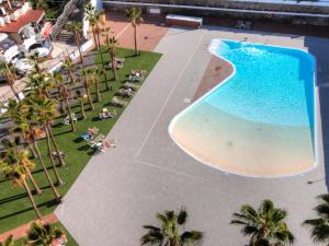 een uitzicht over het zwembad en het strand bij Green Palms Holiday Home in Playa del Inglés