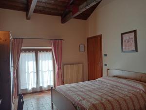 1 dormitorio con cama y ventana en Agriturismo Raimondi Cominesi Amilcare, en Garlasco