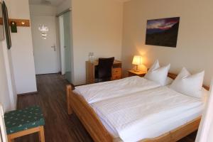 a bedroom with a bed and a desk and a chair at Landhaus am Giessen in Vaduz