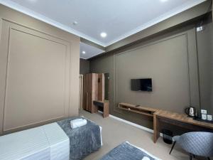1 dormitorio con 1 cama y TV de pantalla plana en Emin hotel, en Ferganá