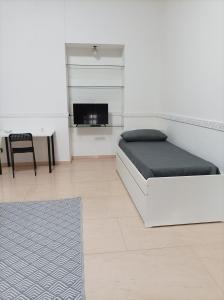 um quarto com uma cama, uma escrivaninha e uma mesa em B&B Nancy em Nápoles