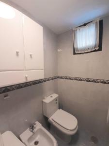 ein Badezimmer mit einem weißen WC und einem Waschbecken in der Unterkunft Loyos - Playa Grande Miño in Miño
