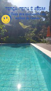 une piscine avec un panneau indiquant tereza feria asin t dans l'établissement Lumiar Eco Lodge - Chalé Telhado Verde, à Nova Friburgo