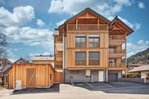 a large wooden building with a balcony at die Tauplitz Lodges - Wasserfall Lodge C1 by AA Holiday Homes in Tauplitz