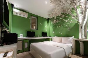 um quarto com uma cama branca e uma parede verde em Nine Star Hotel em Seul