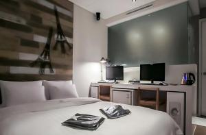 a bedroom with a bed and a desk with two monitors at Nine Star Hotel in Seoul