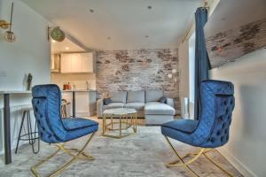 a living room with blue chairs and a couch at * Le Duplex * in Maintenon