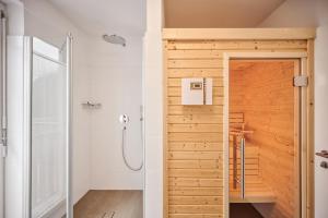 een badkamer met een douche en een houten deur bij die Tauplitz Lodges - Bergblick Lodge B6 by AA Holiday Homes in Tauplitz