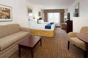 a hotel room with a bed and two couches at Holiday Inn Express & Suites Buffalo, an IHG Hotel in Buffalo