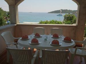 een tafel met stoelen en een tafel met uitzicht op de oceaan bij Secluded fisherman's cottage Cove Dragisina, Kornati - 12150 in Pristanišće