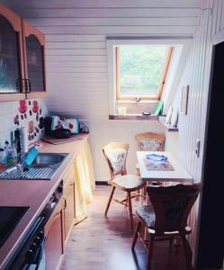 a small kitchen with a small table and chairs at Gemütliche 3 Raum Wohnung im Dachgeschoss in Ehrenfriedersdorf