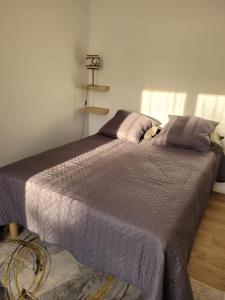 - une chambre dotée d'un grand lit avec des draps et des oreillers violets dans l'établissement Avignon : Appartement le in et off, à Avignon