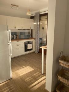 アヴィニョンにあるAvignon : Appartement le in et offのキッチン(白いキャビネット、冷蔵庫付)