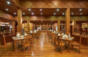 a restaurant with wooden tables and chairs in a room at KMA Inle Hotel in Nyaung Shwe