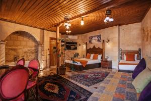 a bedroom with two beds and chairs in a room at Larissa Cave Hotel in Nevşehir