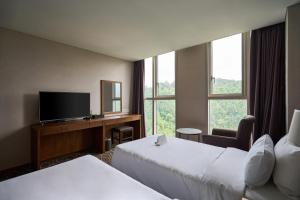 a hotel room with two beds and a flat screen tv at Hotel Square Ansan in Ansan