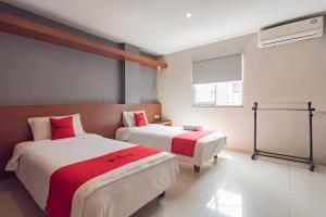 a bedroom with two beds and a window at RedDoorz Plus @ Dago Pojok 3 in Bandung